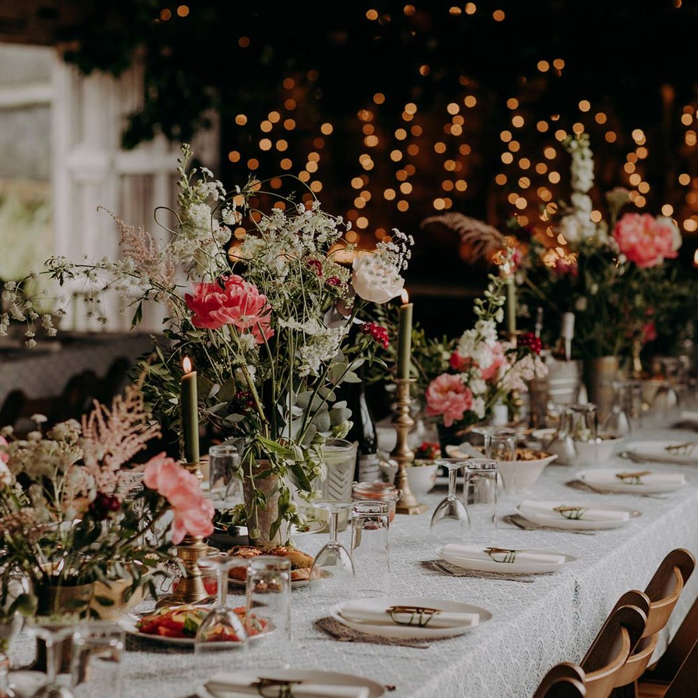 Neutral themed wedding tablescape with green candles and touches of pink flowers at DIY barn wedding