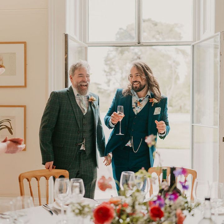 Grooms laugh during personal wedding speeches for intimate reception at Kew Gardens 