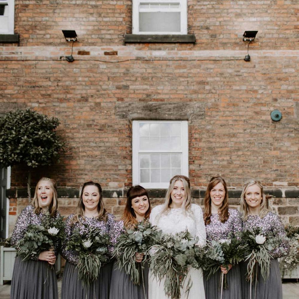 Bridesmaids in charcoal grey long sleeve dresses for a foliage winter wedding with bride in long sleeve wedding dress 