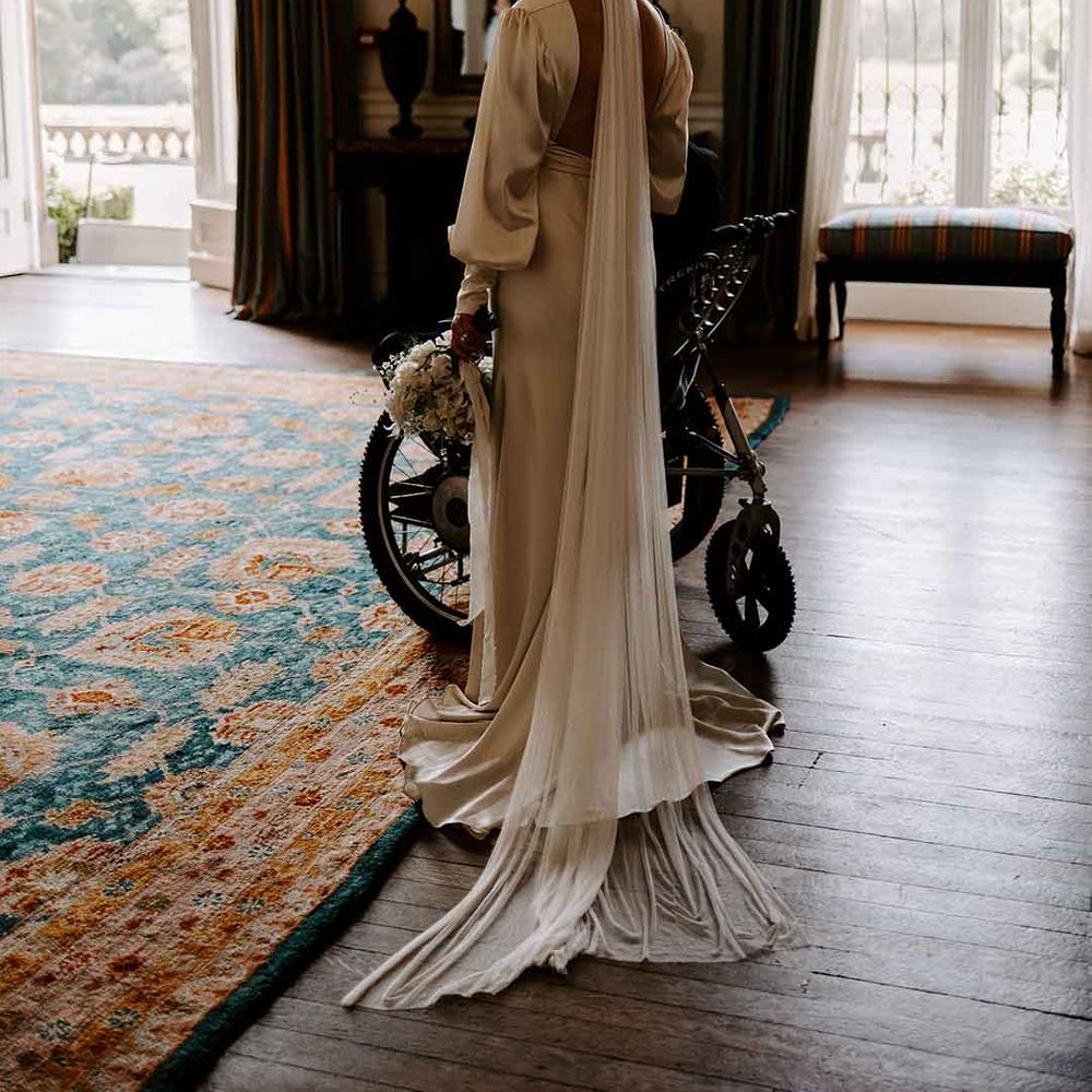 bride in a floor length wedding veil and satin wedding dress