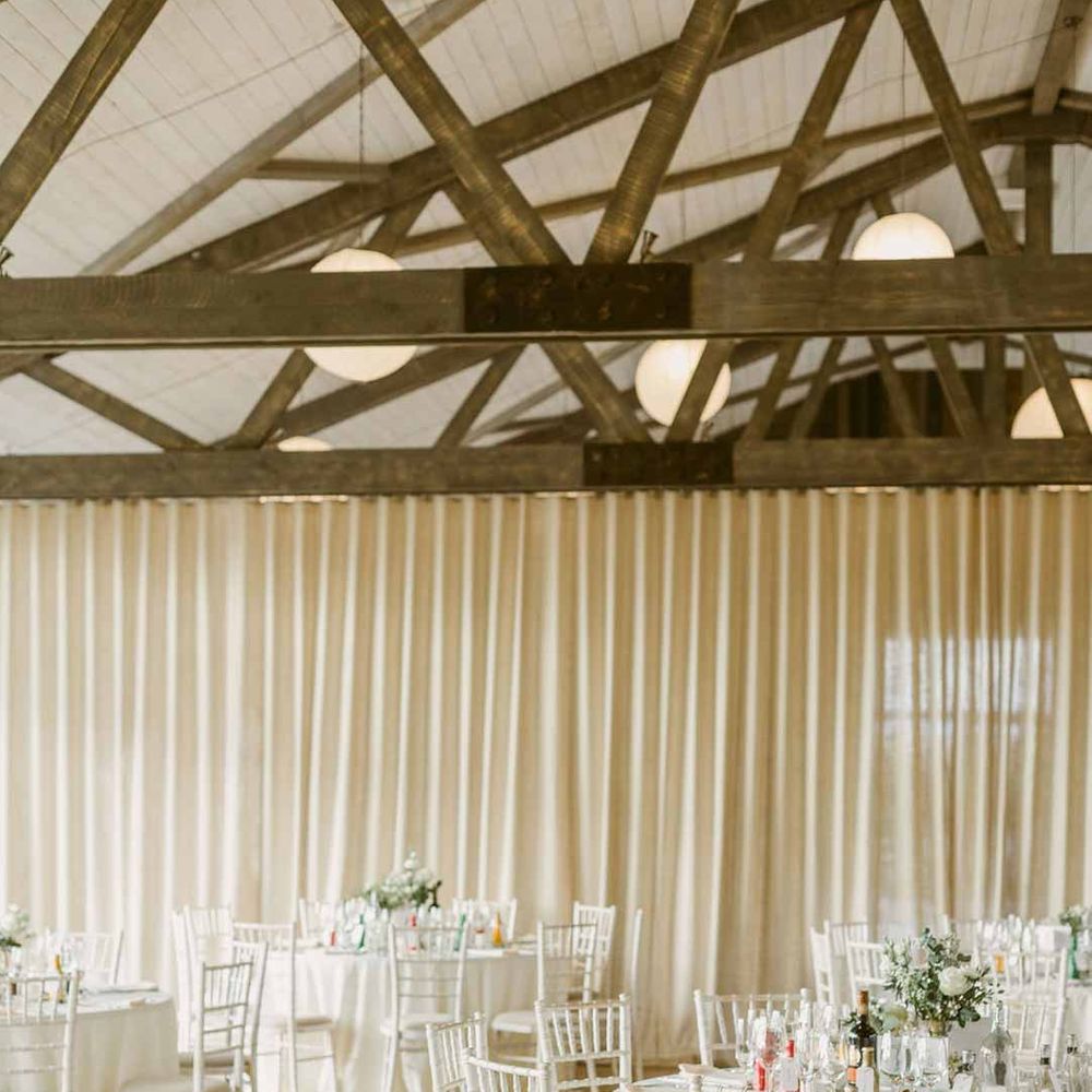 Wedding venues Scotland - Barra Castle wedding venue reception room with classic white tablescapes and off-white curtain