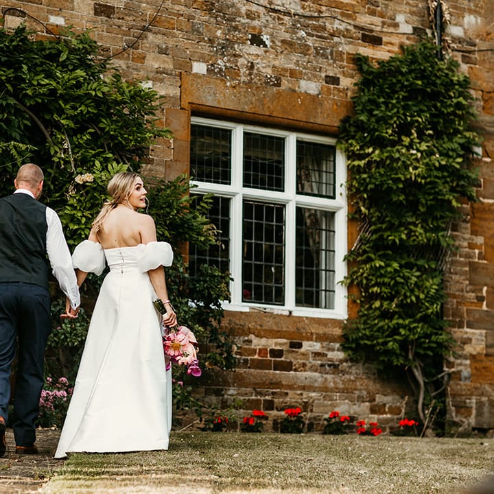 Bride in strapless wedding dress with Jesus Peiro puff sleeves with groom in navy suit 
