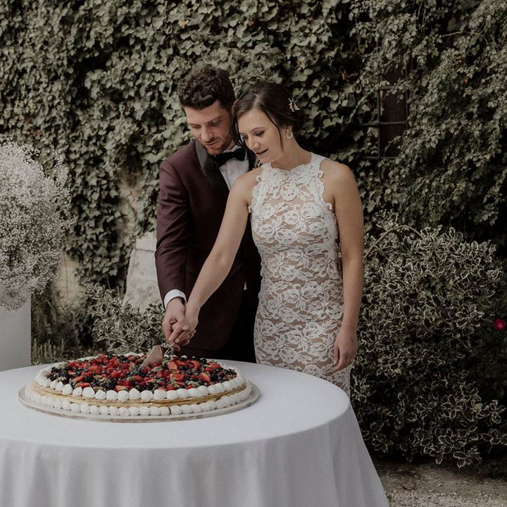 Italian wedding cake being cut by the bride and groom 