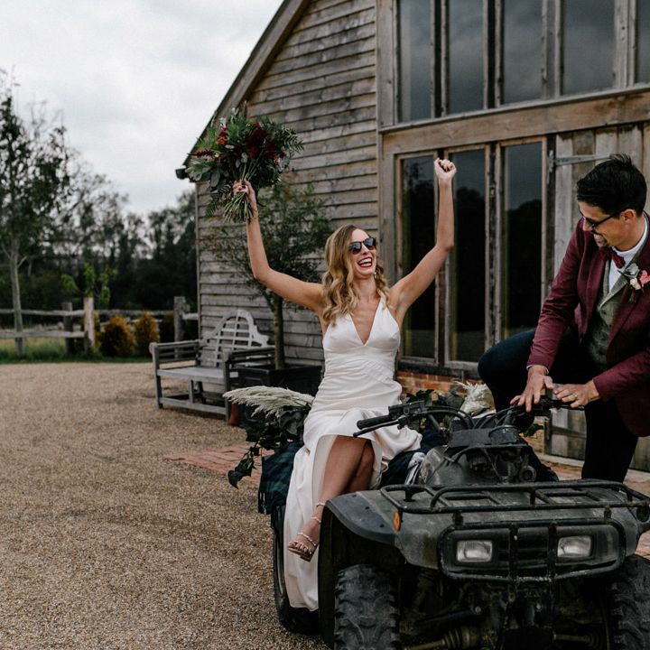Bride in satin wedding dress and groom in burgundy blazer