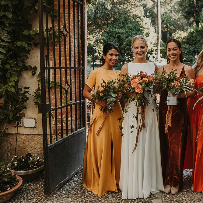 Bridesmaids in mustard, rust and orange dresses for earthy Andalusia wedding 