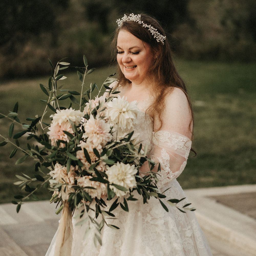 Saskia smiling with her bridal olive bouquet