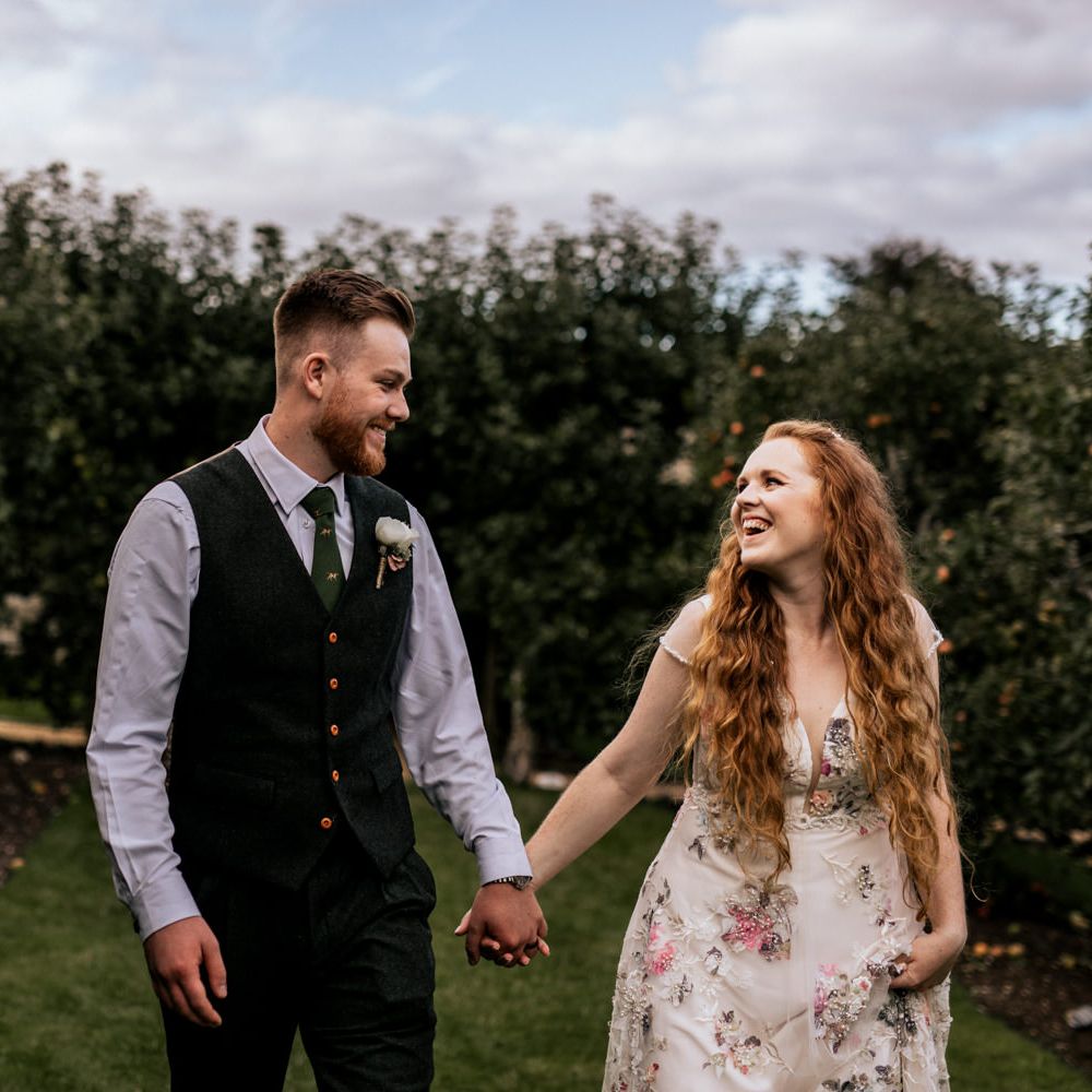 Bride & groom walking through Houghton Lodge Gardens