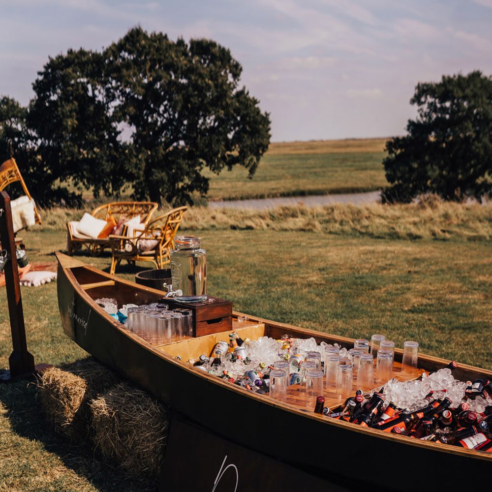 Quirky wooden boat with refreshments for wedding guests at Boho wedding 