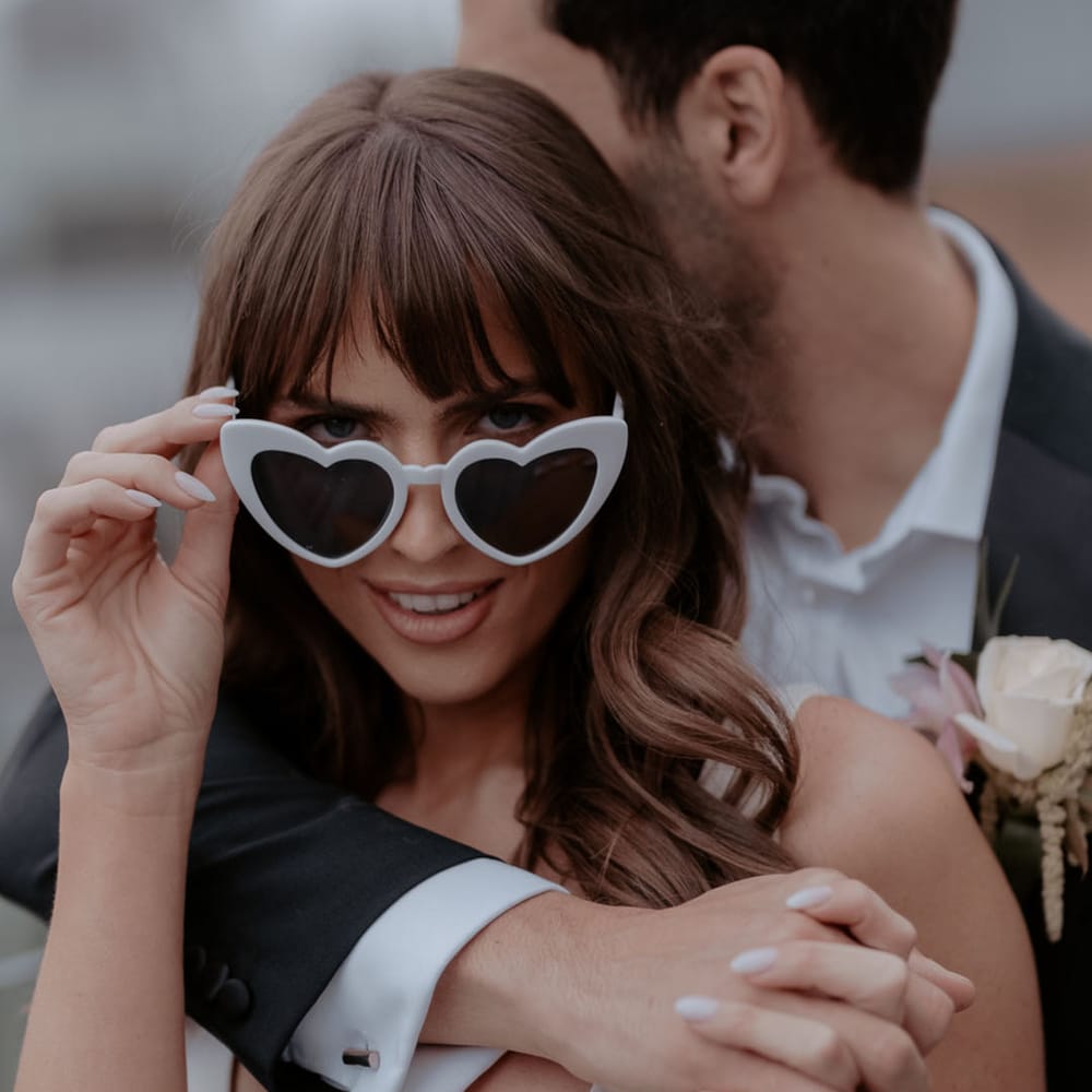 Bride with bangs wearing white retro love heart sunglasses 