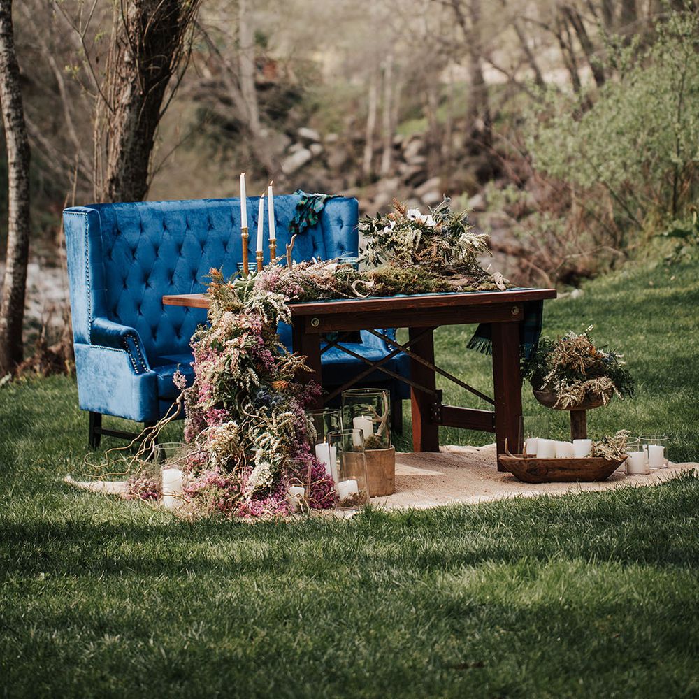 boho wedding elopement with sweetheart table decorated in wildflowers with a blue velvet love seat 