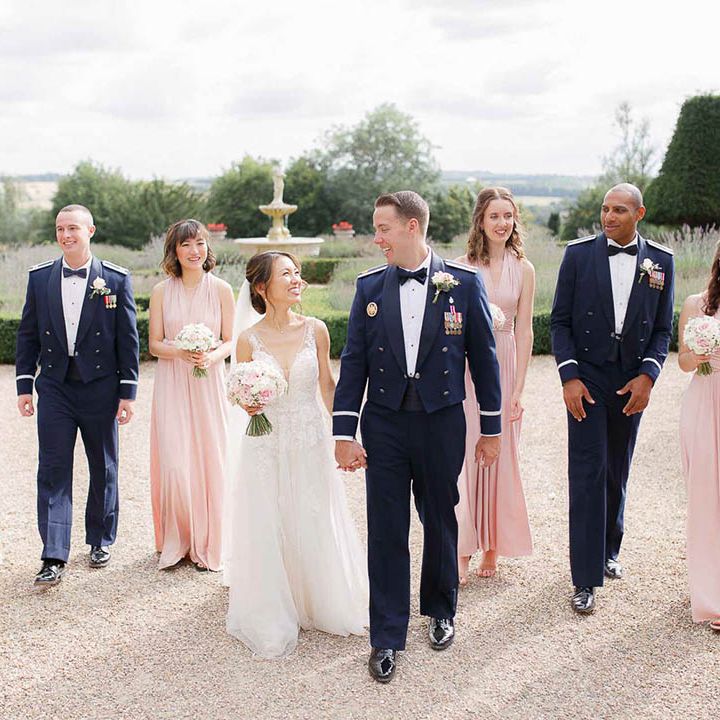 Bride & groom walk together as bridesmaids and groomsmen follow