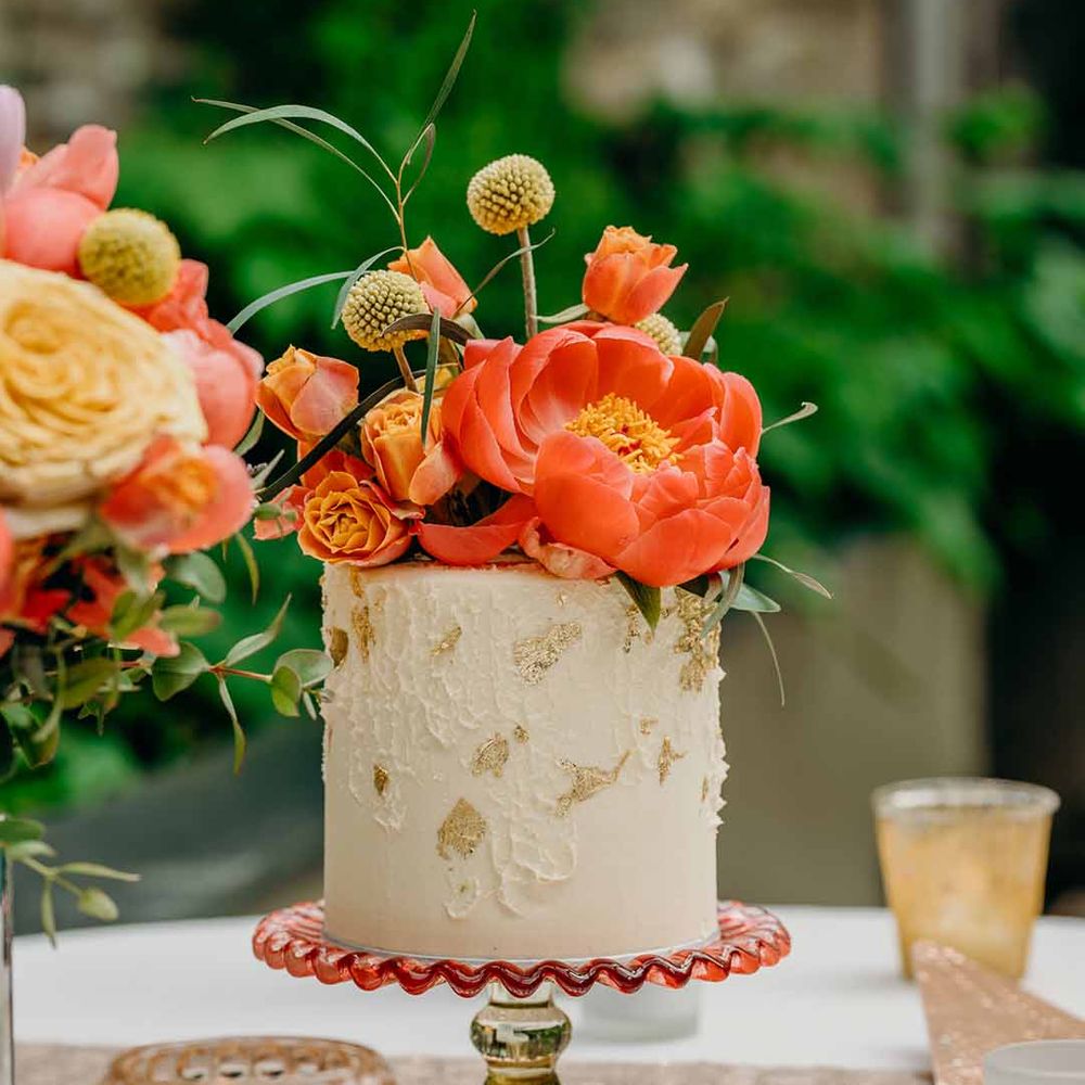 Single tier wedding cake with coral peony cake topper flower