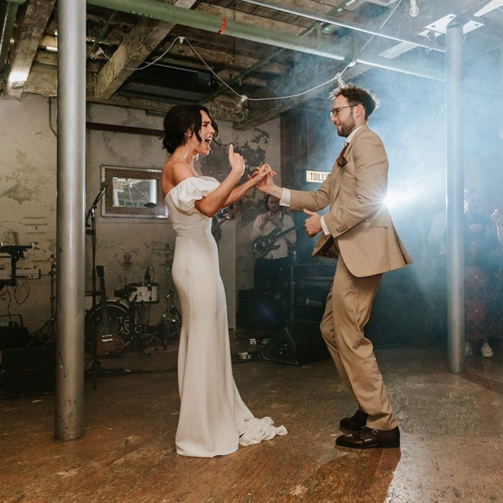 Bride and groom get the party started on the dance floor for 70s party wedding in industrial venue