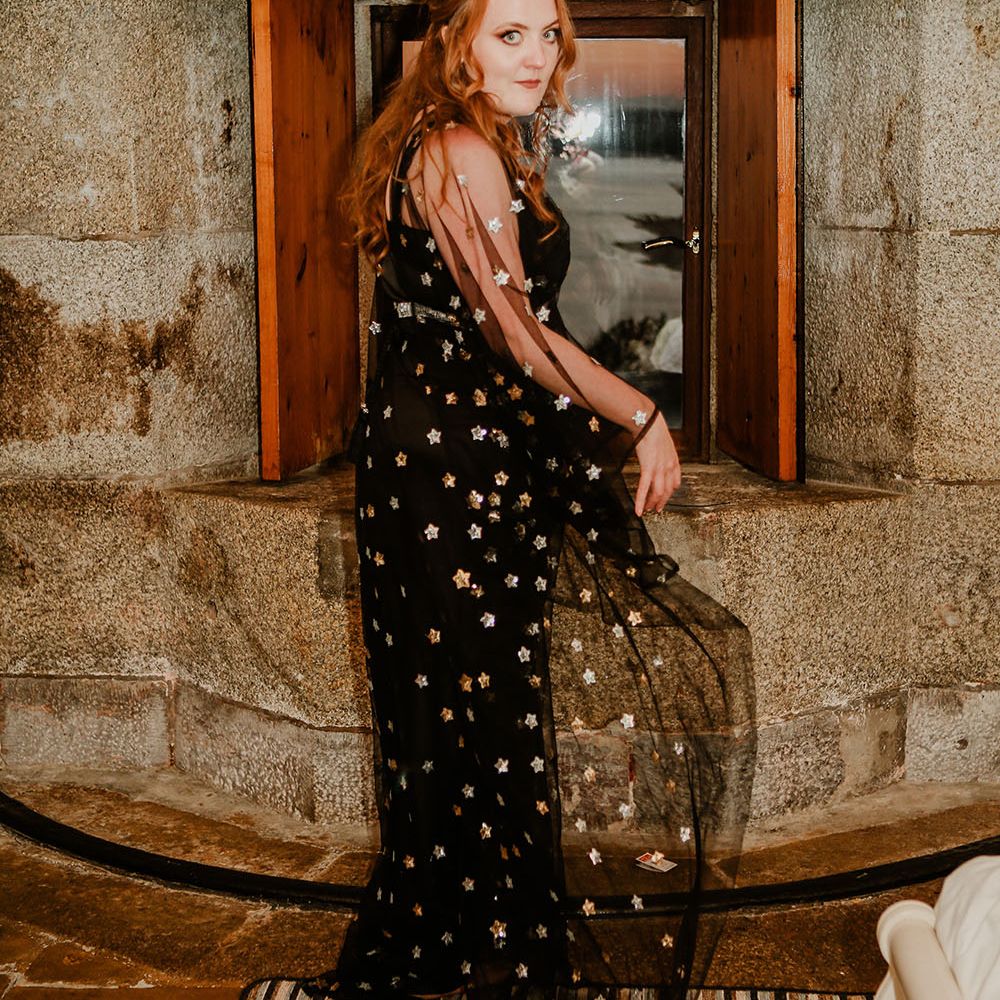 Bride wears black celestial reception dress with sheer sleeves 