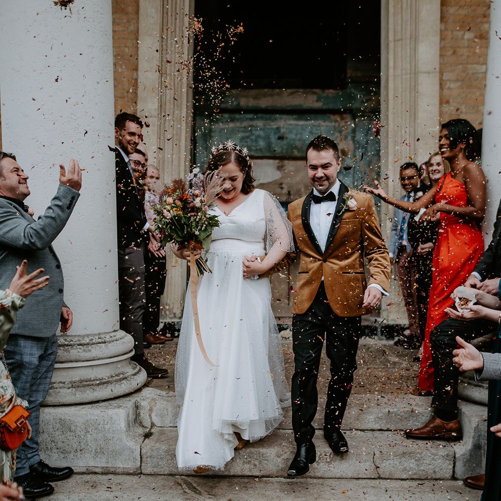 Bride and Groom exit chapel into autumnal themed confetti throw at London Wedding Venue