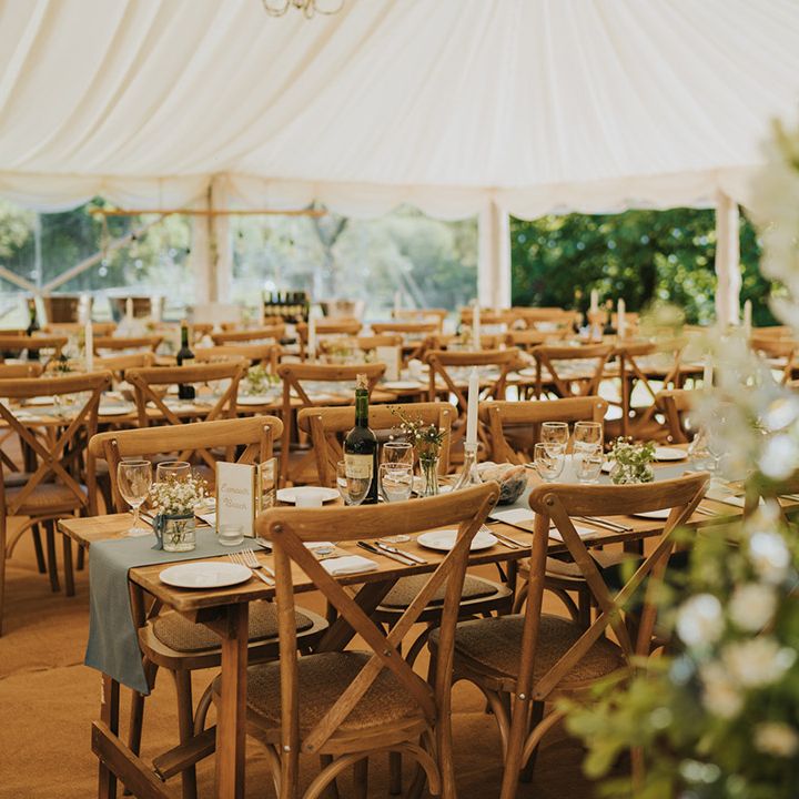 Marquee wedding reception at Badgers Holt with simple foliage decorations and blue wedding decor