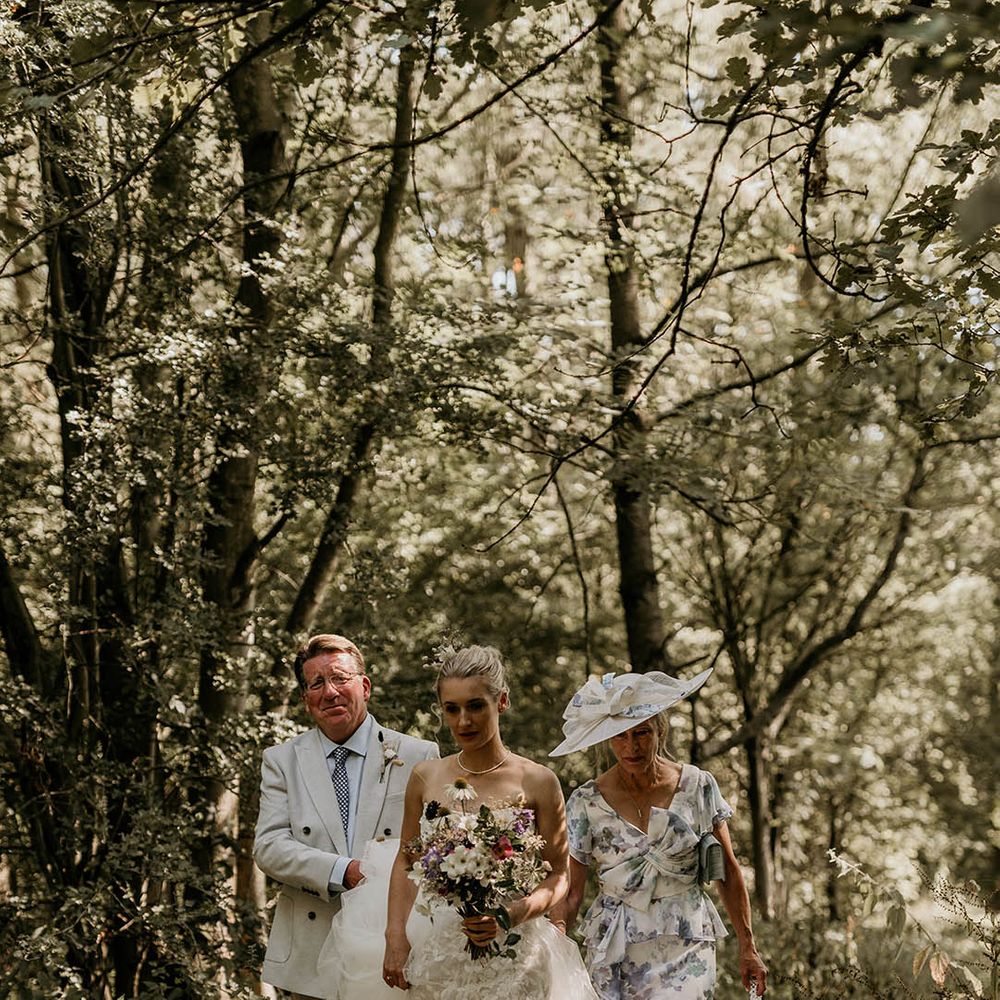 Camp Katur wedding with the bride's parents in white and blue outfits walking her down the aisle 