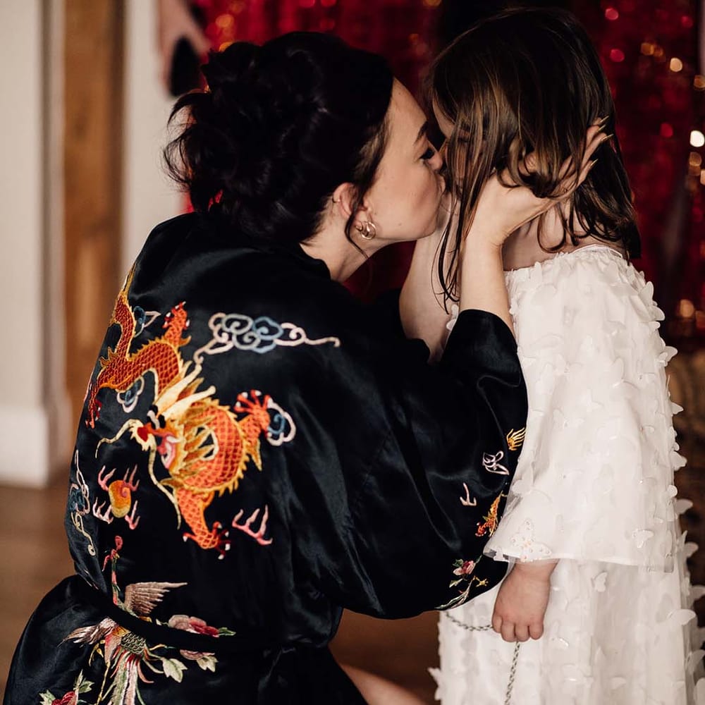 Bride in black dragon pattern satin robe as she gets ready for the wedding day 