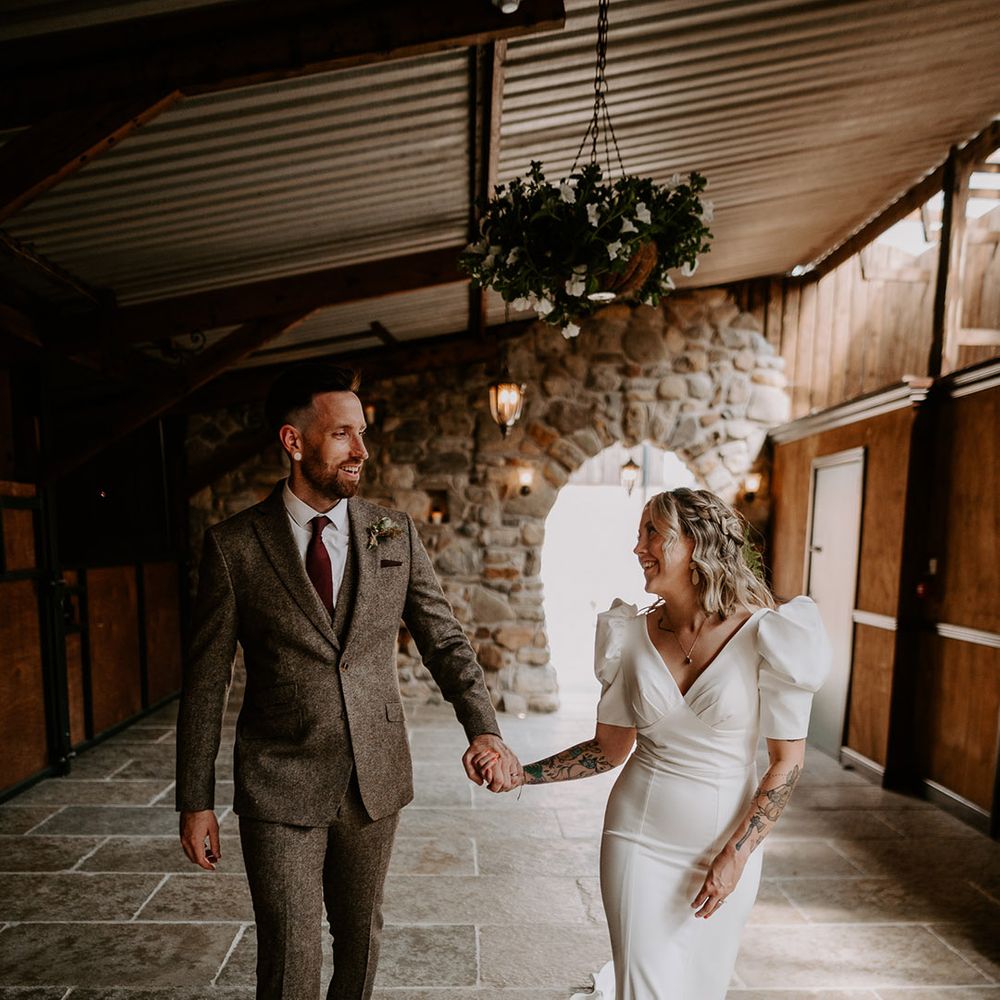 Groom in grey tweed suit with the bride in a statement puff sleeve wedding dress 