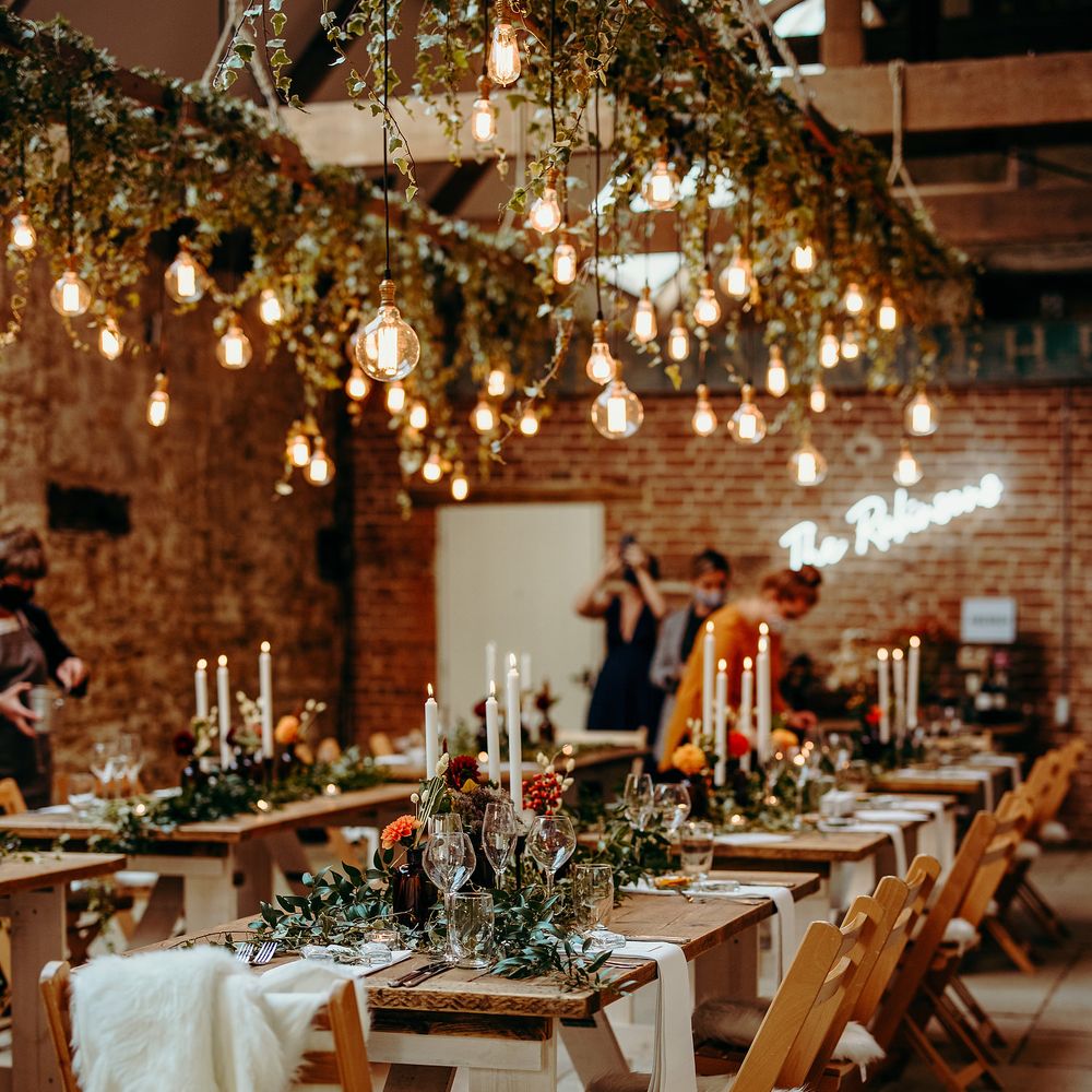 Rustic venue with wooden tables, hanging ivy and lighting 