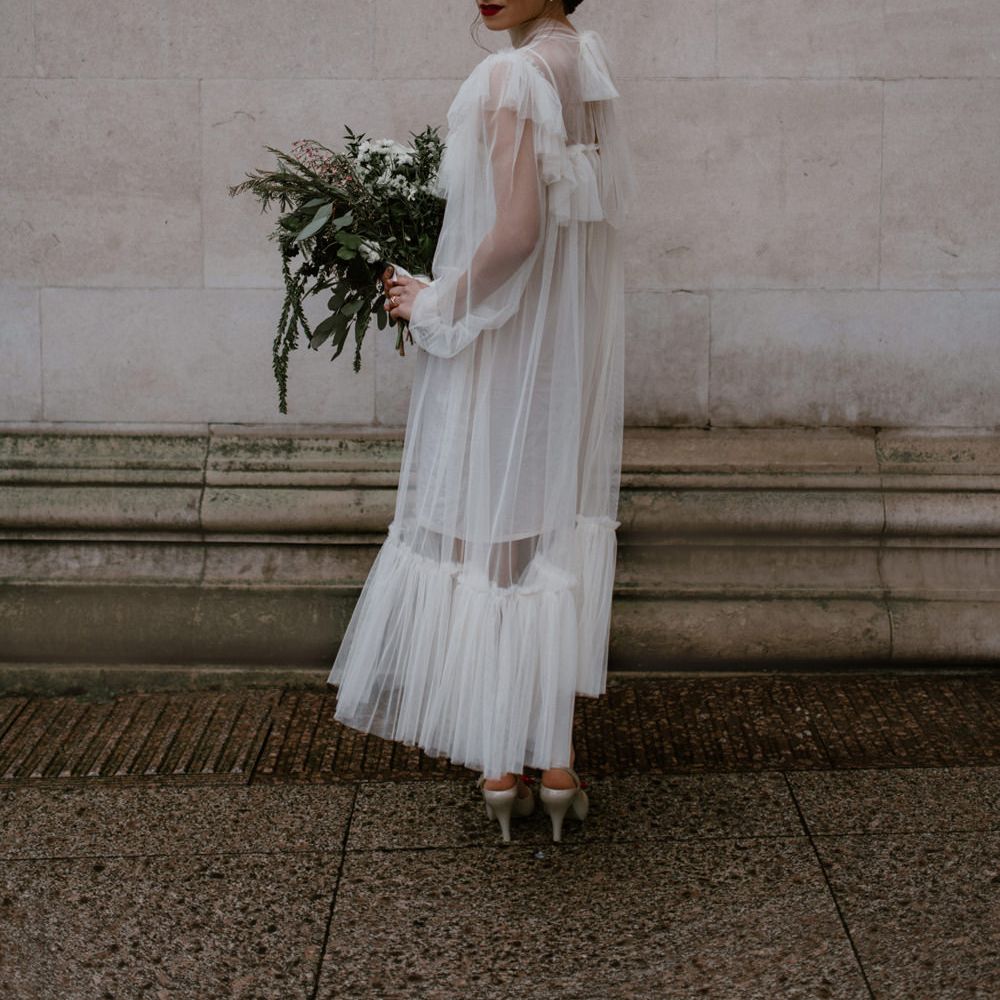 Layered tulle wedding dress with ruffled hem and bid detail 
