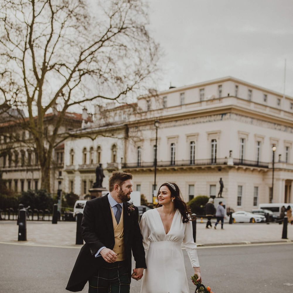 London wedding day photography, bride wears long sleeve wedding dress and front slit, groom wears tartan trousers