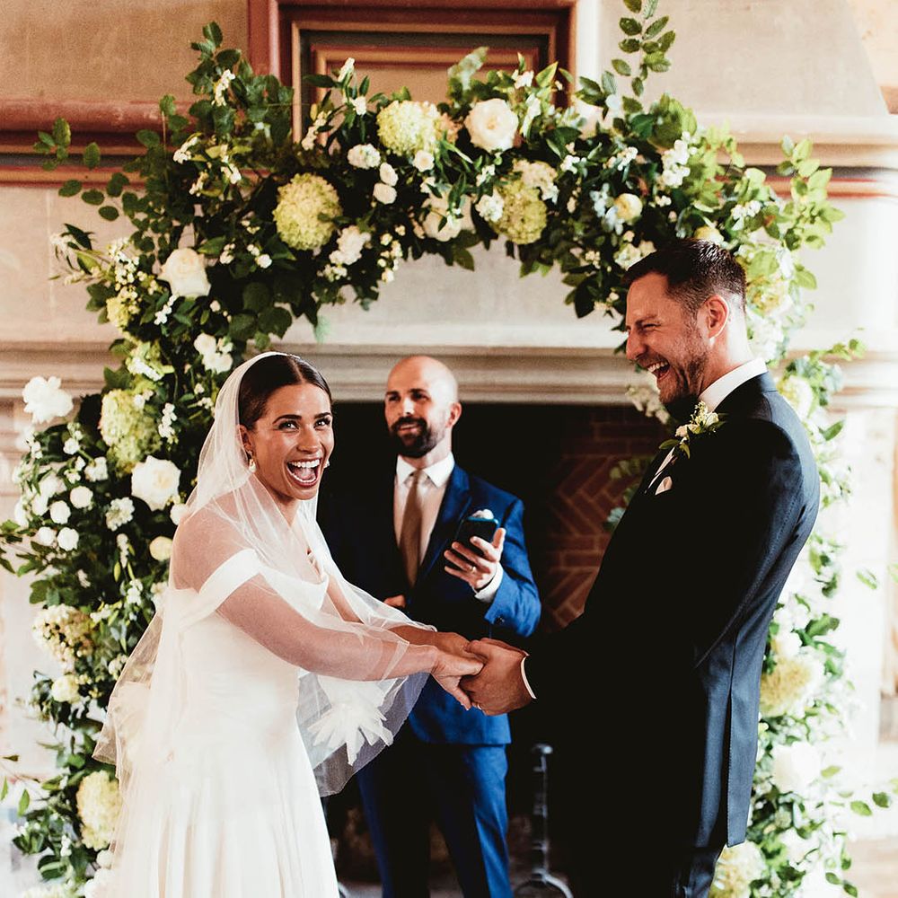Bride & groom hold hands during wedding ceremony