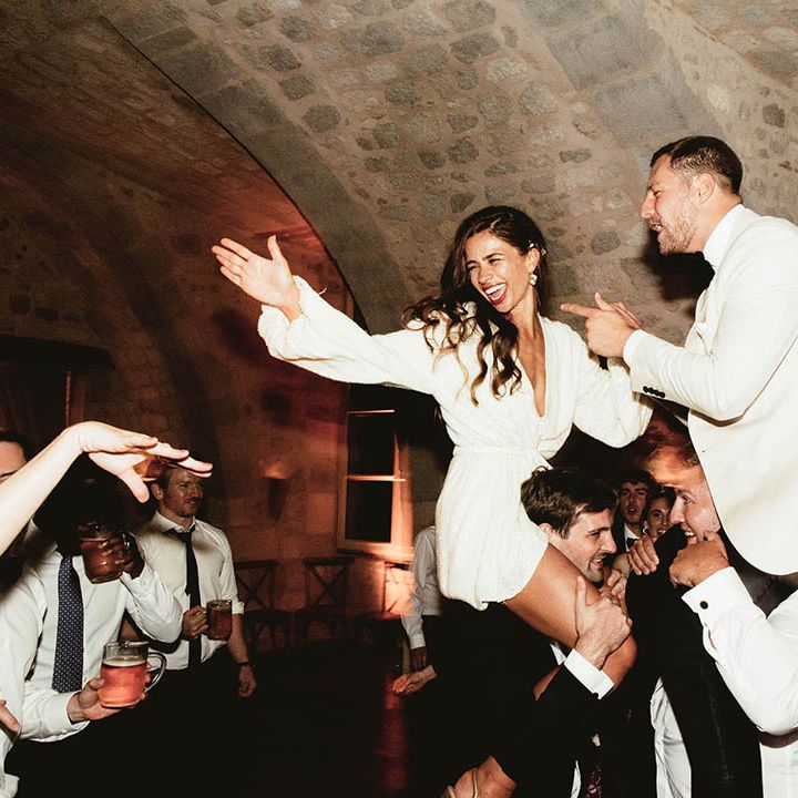 Bride & groom dance on the shoulders of wedding guests on their wedding day