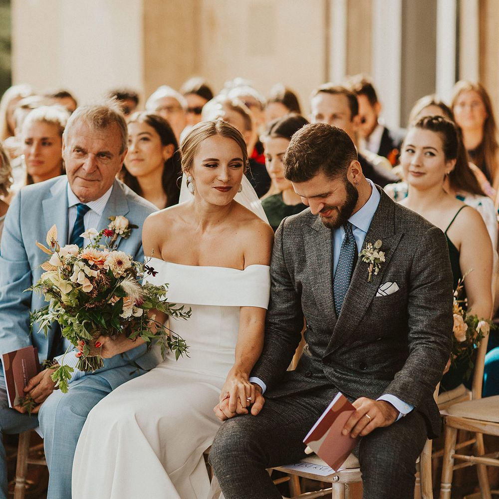 Bride looks at groom on wedding day and smiles during ceremony