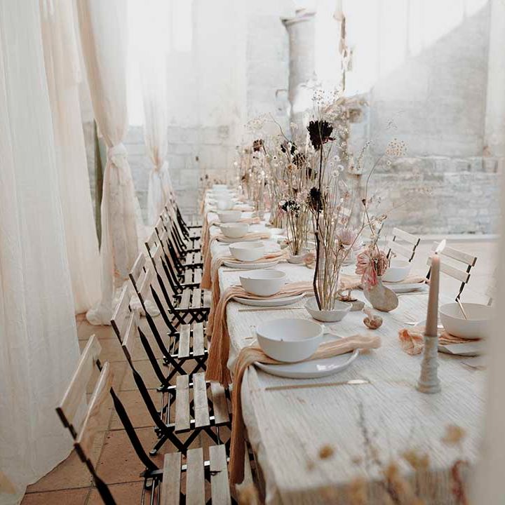 Place settings with charger plate, natural linen napkin, bowl and gold cutlery 
