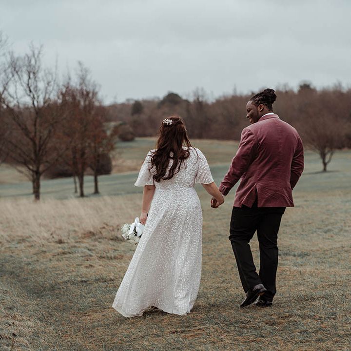 Bride & groom walk across fields on their wedding day
