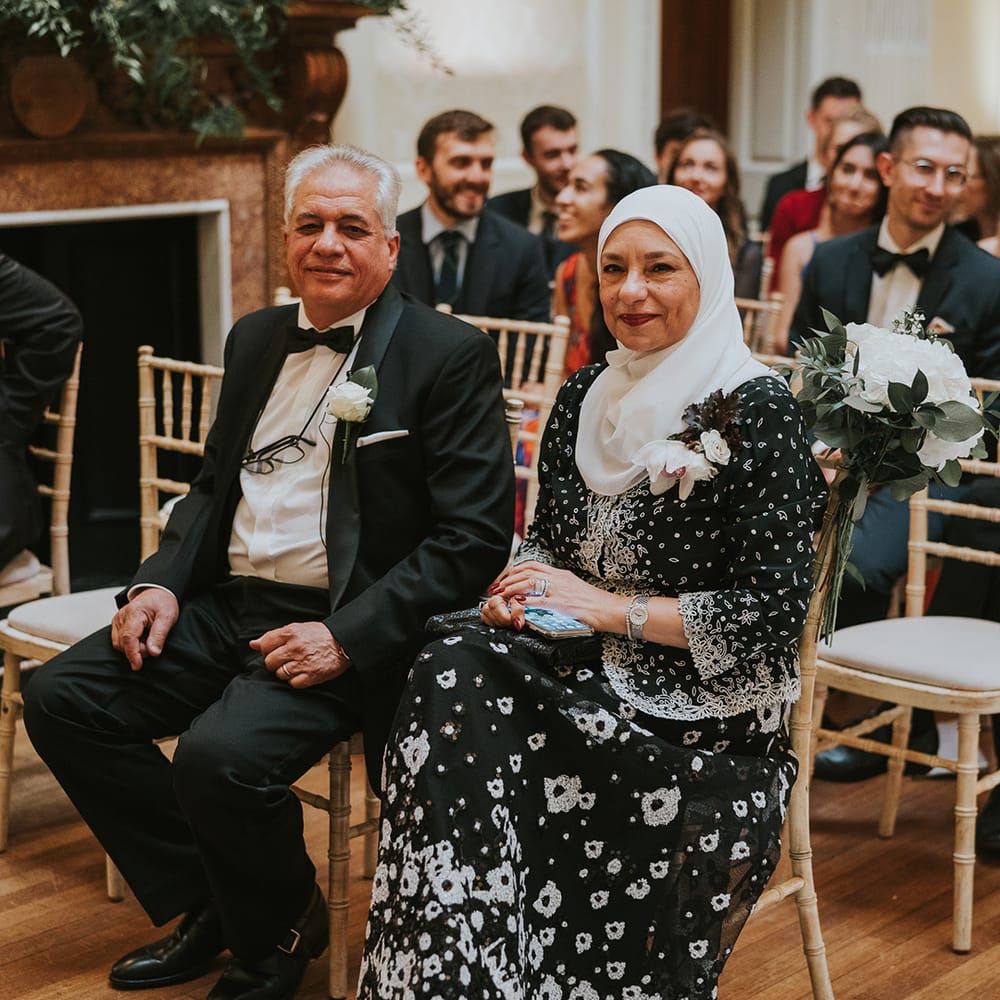 Wedding guests and family members sit watching the wedding ceremony 
