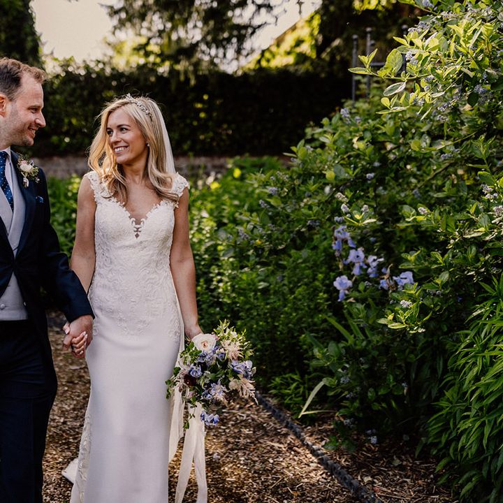 Bride looks into the groom's eyes as they walk together for their couple portraits 