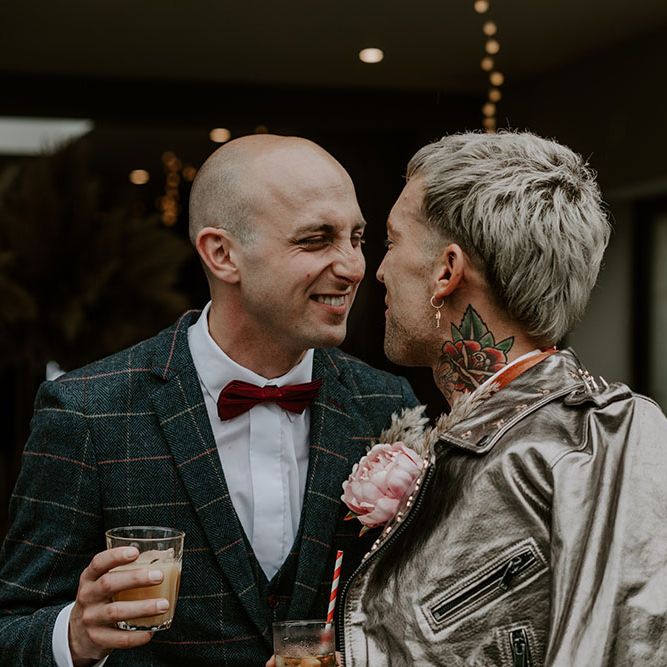 Groom wears red bow tie and tartan blazer with white shirt 