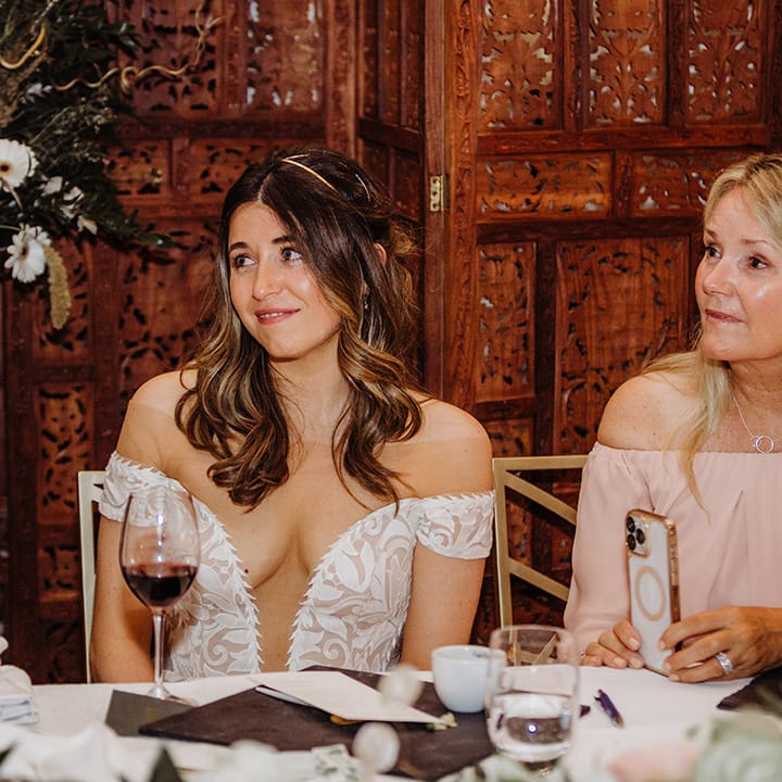 Bride in off the shoulder boho lace wedding dress with a pretty gold headband 