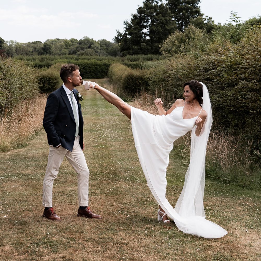 Chloe Bruce martial arts coach jokingly kicks her husband during outdoors couples portraits 