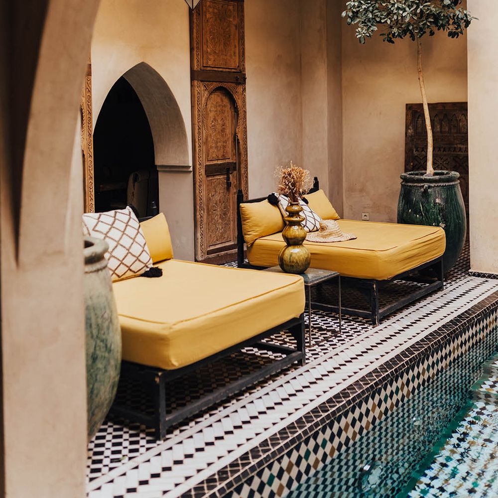 Yellow love seat lounging day beds at Moroccan wedding venue 