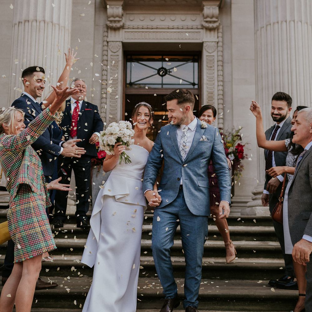 Confetti moment with bride in Roland Mouret strapless wedding dress