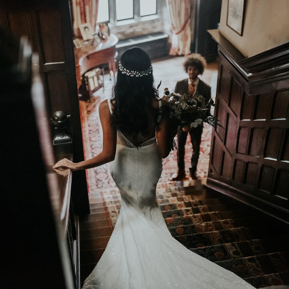 Bride in embellished wedding dress and hair vine walking down the stairs at Hooton Pagnell Hall