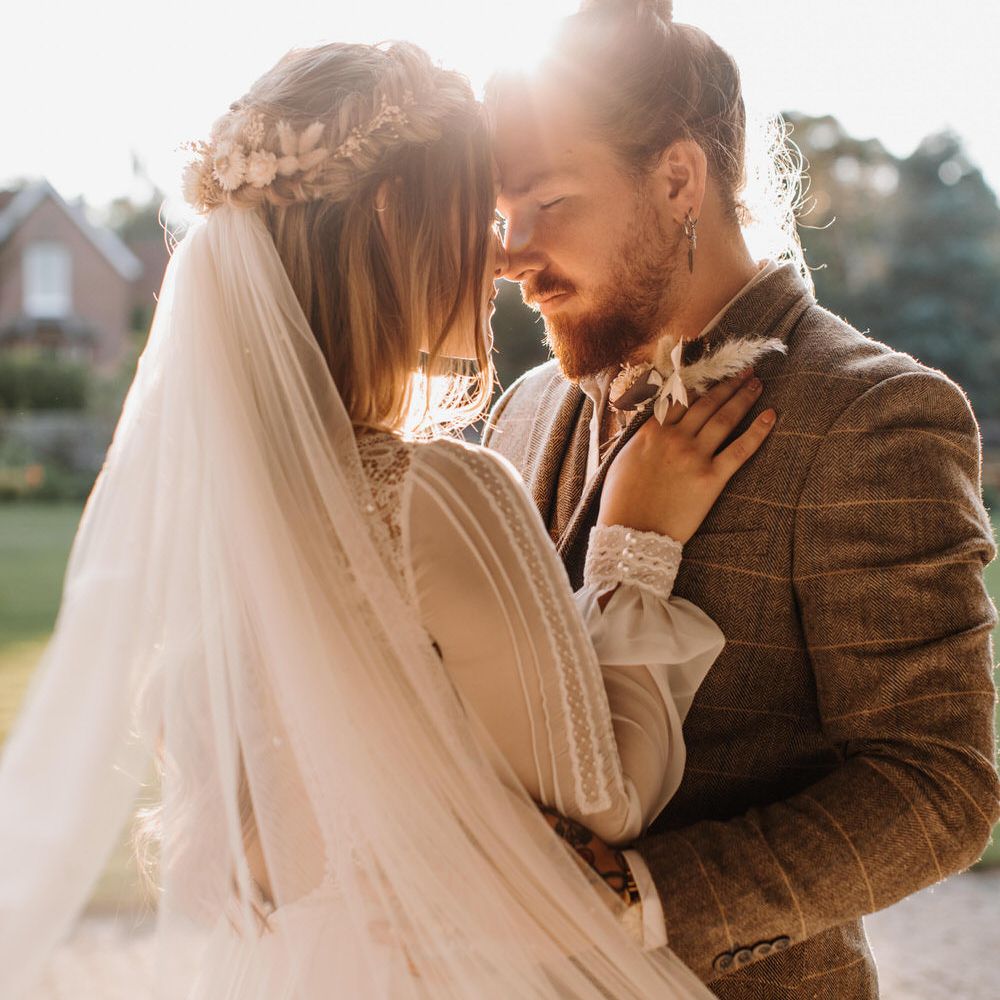 Boho luxe wedding photography of bride and groom kissing with soft natural lighting