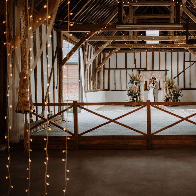 Barn wedding with white fairy lights and macrame backdrop 
