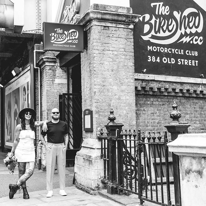 Black and white portrait of an alternative bride and groom outside The Bike Shed in Shoreditch 