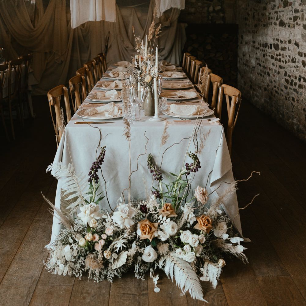 Modern luxury wedding reception with draped ceiling and dried and fresh flower arrangements 