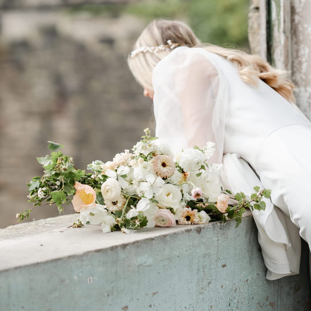 Romantic pastel white, pink and peach wedding bouquet with foliage 