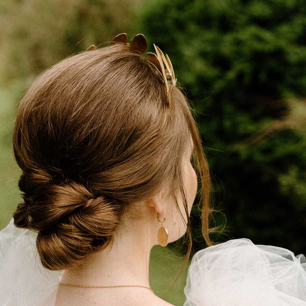 Bride with elegant pinned up wedding hairstyle wearing a gold headdress 