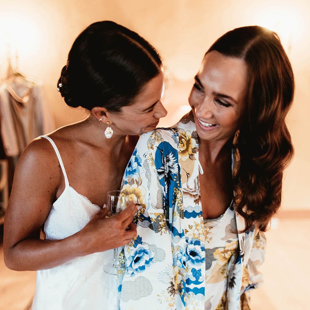 Bride hugs her bridesmaid on the morning of her wedding day
