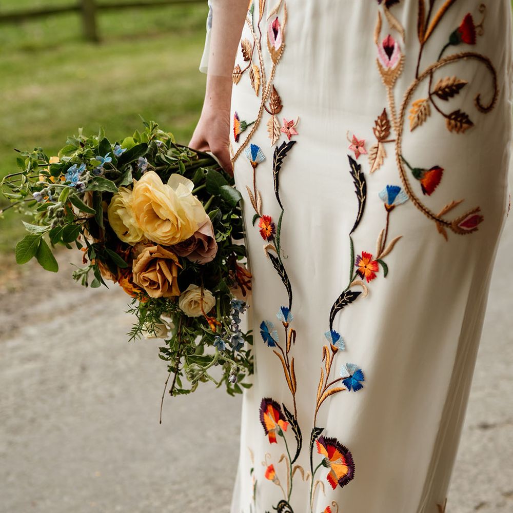 Close up of the colourful details on the bride's wedding dress from Temperley Bridal 