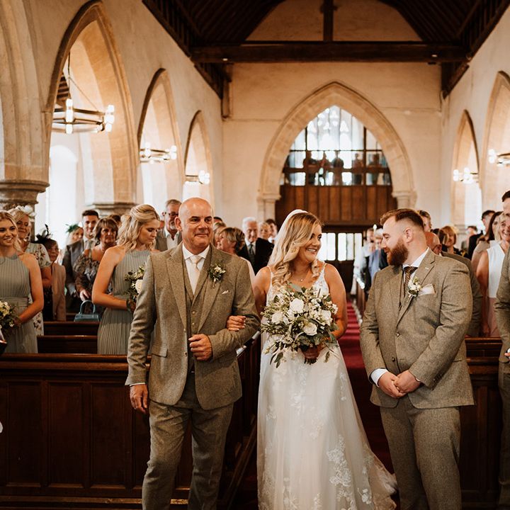 The groom smiles as he sees the bride for the first time 