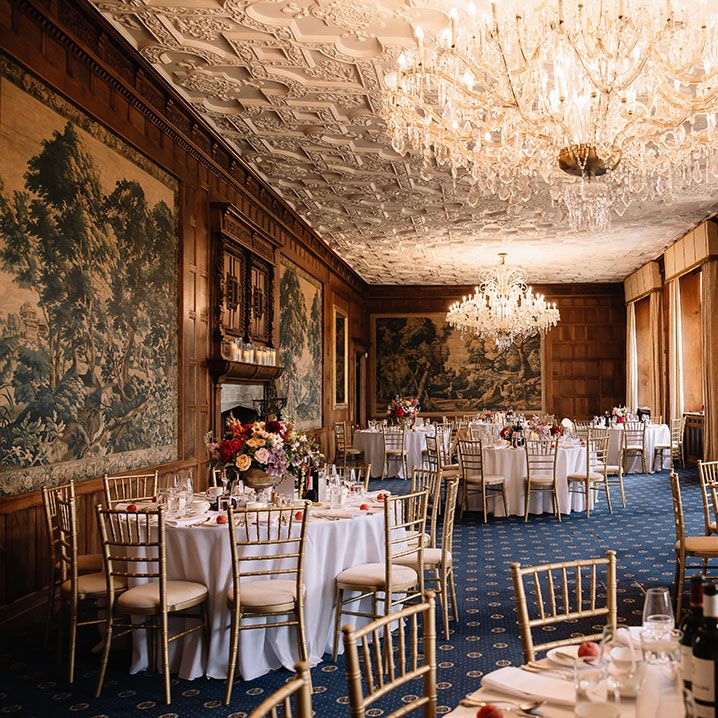North Mymms Park wedding venue reception room with chandelier and luxury wedding table settings with vibrant flower centrepieces 
