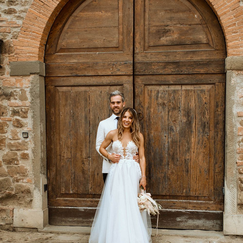 Couple portrait featuring bride in tulle embroidered plunge wedding dress and groom in relaxed linen wedding suit
